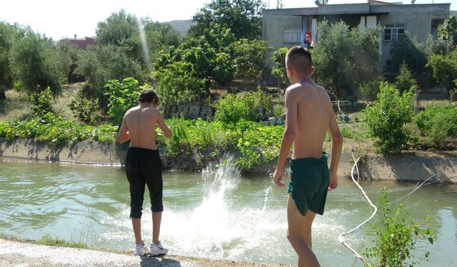 Sıcak bunaltınca yüzmesi yasak olan kanalda serinlediler