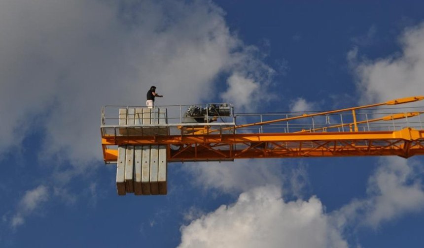 Maaşını alamayınca vincin tepesine çıktı
