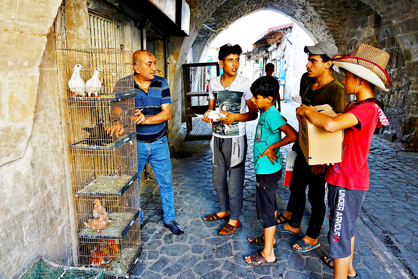 Şanlıurfalı gençler, bir dükkanında güvercinlerini satmaya çalışıyorlar
